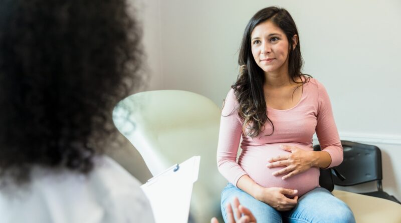 A pregnant person speaking with their doctor